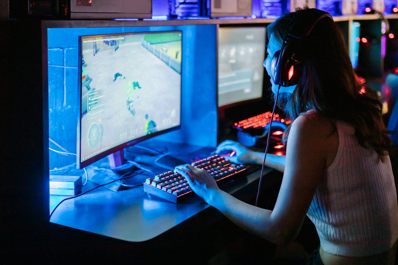 about-01 Woman enjoying a vibrant gaming session at a computer setup with a mechanical keyboard.